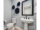 Stylish powder room with pedestal sink, modern fixtures, and decorative wall art at 1217 Margo Mannor Dr, Fort Mill, SC 29708