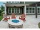 Covered patio features Adirondack chairs with stone firepit at 1244 Weir Ct, Fort Mill, SC 29708