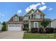 Inviting two-story home featuring a stone-accented garage and a beautifully landscaped front yard at 1244 Weir Ct, Fort Mill, SC 29708