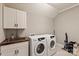 Functional laundry room with modern washer, dryer, sink, and storage cabinets at 1244 Weir Ct, Fort Mill, SC 29708