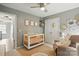Bedroom with crib, rocking chair, and closet featuring neutral decor and soft lighting at 147 Whitley Mills Rd, Fort Mill, SC 29708
