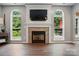 Bright living room features a stone fireplace, built-in TV, and large windows offering great natural light at 147 Whitley Mills Rd, Fort Mill, SC 29708