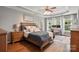 Primary bedroom with tray ceiling, ceiling fan, hardwood floors, and a work space near the windows at 147 Whitley Mills Rd, Fort Mill, SC 29708