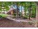 Backyard with a stone pathway and mature trees, creating a peaceful and natural setting at 1525 Valhalla Dr, Denver, NC 28037