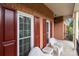 Close up view of a lovely porch with white wicker chairs, red shutters, and brick exterior at 1525 Valhalla Dr, Denver, NC 28037