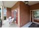 Welcoming brick front porch with white wicker chairs and red shutters at 1525 Valhalla Dr, Denver, NC 28037