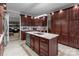 A kitchen featuring an island with a stainless steel sink, granite countertops, and cherry wood cabinets at 1525 Valhalla Dr, Denver, NC 28037