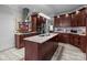 A kitchen featuring an island with a stainless steel sink, granite countertops, and cherry wood cabinets at 1525 Valhalla Dr, Denver, NC 28037