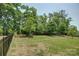 Large grassy backyard, fenced and surrounded by mature trees, offers privacy and space at 15344 Cimarron Hills Ln, Charlotte, NC 28278