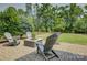 Charming backyard patio with a stone fire pit and Adirondack chairs provides an intimate setting at 15344 Cimarron Hills Ln, Charlotte, NC 28278