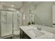 Bright bathroom with white countertop, dark cabinets, and tiled glass-enclosed shower at 15344 Cimarron Hills Ln, Charlotte, NC 28278