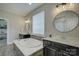 Luxurious bathroom with a soaking tub, dual sinks, white countertop, and modern fixtures at 15344 Cimarron Hills Ln, Charlotte, NC 28278