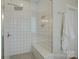 Bright bathroom with a glass shower, tiled walls, a built-in seat, and modern fixtures at 15344 Cimarron Hills Ln, Charlotte, NC 28278