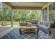 Spacious covered patio features comfortable seating, a patterned rug, and an inviting view of the outdoor landscape at 15344 Cimarron Hills Ln, Charlotte, NC 28278