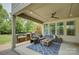 Covered patio with an outdoor kitchen, cozy seating, and fan for a relaxing atmosphere at 15344 Cimarron Hills Ln, Charlotte, NC 28278