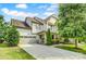 Beautiful two-story home with a two-car garage and manicured landscaping on a sunny, partially cloudy day at 15344 Cimarron Hills Ln, Charlotte, NC 28278