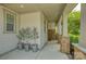 Inviting front porch featuring stone pillars, potted plants, and a neutral color palette for a warm welcome at 15344 Cimarron Hills Ln, Charlotte, NC 28278