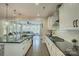 Open concept kitchen with black countertops, white cabinets, stainless appliances, and views to the living area at 15344 Cimarron Hills Ln, Charlotte, NC 28278