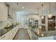 Bright kitchen with stainless steel appliances, a gas cooktop, and a large island with modern lighting at 15344 Cimarron Hills Ln, Charlotte, NC 28278