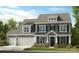 Charming two-story home with a three car garage, well-manicured lawn, and covered porch at 18129 Sulton Ter, Huntersville, NC 28078