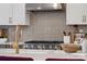 Gourmet kitchen featuring a stainless steel range hood, a tile backsplash, and modern fixtures at 18129 Sulton Ter, Huntersville, NC 28078