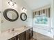 Bright bathroom with dual sinks, updated lighting fixtures, and a garden tub at 199 Ashmont Dr, Kannapolis, NC 28081