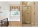 Bright bathroom with a soaking tub, a separate shower, and a stylish window treatment at 199 Ashmont Dr, Kannapolis, NC 28081