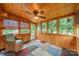 Cozy sunroom featuring wood paneled walls, multiple windows and a ceiling fan at 199 Ashmont Dr, Kannapolis, NC 28081