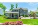Rear view showing a patio, screened-in porch, and well-maintained yard with colorful landscaping at 208 South Shore Dr, Belmont, NC 28012