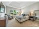 Comfortable bedroom with a tufted headboard, a tray ceiling, large windows with natural light, and neutral tones at 208 South Shore Dr, Belmont, NC 28012