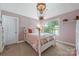 Charming bedroom with pink paneled walls, a white frame bed, carpet floors, and a unique light fixture at 208 South Shore Dr, Belmont, NC 28012
