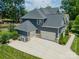 Rear exterior view featuring a three-car garage and well-maintained landscaping in a suburban community at 208 South Shore Dr, Belmont, NC 28012
