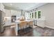 Modern kitchen featuring white cabinets, stainless steel appliances, an island with seating, and large windows at 208 South Shore Dr, Belmont, NC 28012