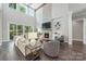 Bright living room with tall windows, a stone fireplace, and stylish modern furnishings at 208 South Shore Dr, Belmont, NC 28012