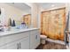 Bright bathroom featuring a double vanity, unique pirate-themed shower curtain, and wood-look flooring at 2859 Sherrills Stream Dr, Sherrills Ford, NC 28673