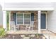 Inviting front porch featuring white rocking chairs and decorative stone accents, creating a cozy outdoor space at 2859 Sherrills Stream Dr, Sherrills Ford, NC 28673