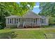 Charming single-story home with gray siding, a front porch, and lush green landscaping at 2934 Drakes Crossing Dr, Charlotte, NC 28262