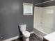 Bathroom with a toilet and shower-tub combo, enhanced by a window for natural light and ventilation at 303 Southern Ave, East Spencer, NC 28039