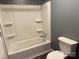 Bathroom with white tub-shower combo and built-in shelving, offering a practical and clean design at 303 Southern Ave, East Spencer, NC 28039
