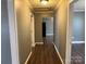 Hallway with hardwood floors and neutral paint leading to the kitchen and other rooms at 303 Southern Ave, East Spencer, NC 28039