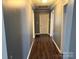 Hallway with hardwood floors, white trim and doors, and neutral paint at 303 Southern Ave, East Spencer, NC 28039