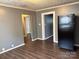 Living room with black refrigerator, hardwood floors, neutral walls, and white trim at 303 Southern Ave, East Spencer, NC 28039