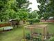 Lush backyard with a garden, picnic area, and storage shed, perfect for outdoor enjoyment and relaxation at 3042 Cresthill Dr, Charlotte, NC 28212