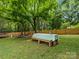 Large backyard features a covered dining area, mature trees, and a trampoline, perfect for outdoor gatherings at 3042 Cresthill Dr, Charlotte, NC 28212
