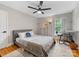 Inviting bedroom featuring a gray bed with neutral bedding, a ceiling fan, and a large window at 3042 Cresthill Dr, Charlotte, NC 28212