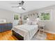 This bedroom has a ceiling fan, two windows, and hardwood floors at 3042 Cresthill Dr, Charlotte, NC 28212