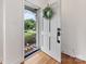 Bright entryway with hardwood floors, a white door with wreath, and a view to the yard at 3042 Cresthill Dr, Charlotte, NC 28212