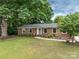 Charming brick home with a landscaped front yard, mature trees, and a welcoming entrance at 3042 Cresthill Dr, Charlotte, NC 28212