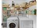 Bright laundry room with a washer, dryer, and open shelving for storage at 3042 Cresthill Dr, Charlotte, NC 28212