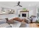 Cozy living room featuring a brick fireplace, hardwood floors, and an open view to the kitchen at 3042 Cresthill Dr, Charlotte, NC 28212